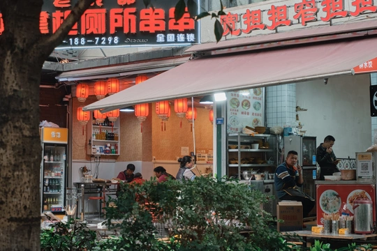 坐在餐厅前面的桌子旁的一群人