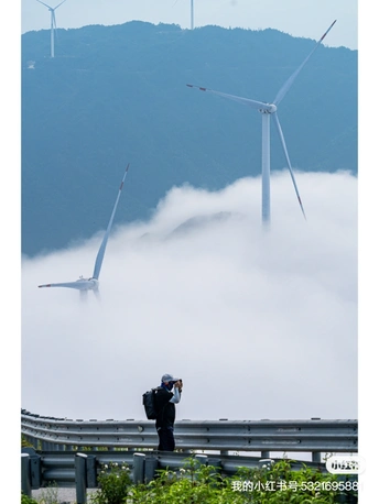 一个人正在拍摄一个风力发电厂 风力发电机在雾中矗立。