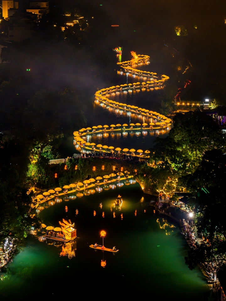 阳朔遇龙河金龙巡游夜影，灯船绘就的水墨长卷。