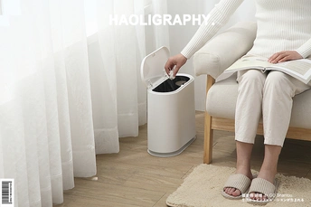 一位怀孕的妇女坐在白色的椅子上阅读杂志。