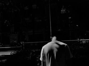 一个穿着黑白衣服的男子在夜晚沿着人行道滑着滑板