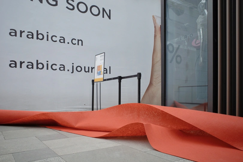 带有红色丝带的入口和墙上挂着一块牌子