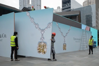 一个人站在一栋建筑前 建筑侧面有一个大的人形剪影。