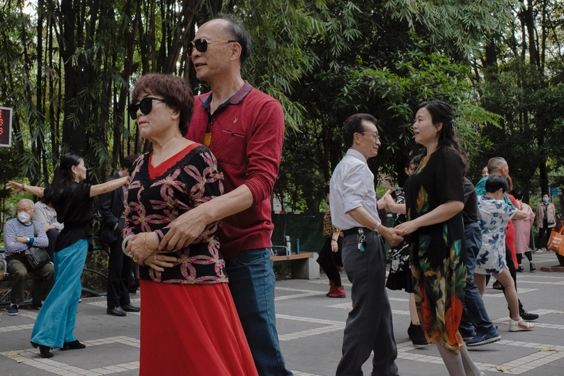 一个人和一个女人站在街上 人们经过。