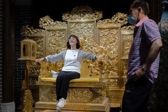 一个男子和女子坐在金色的椅子上 戴着面具。