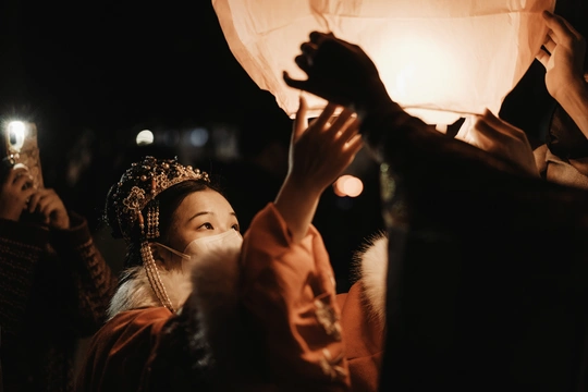 夜晚举起灯笼向天空的女人