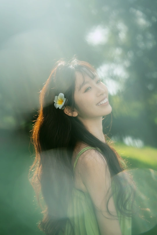 一位穿着绿色连衣裙 头戴白色花朵的年轻女子肖像