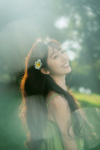 一位穿着绿色连衣裙 头戴白色花朵的年轻女子肖像