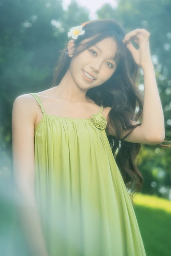 美丽的年轻女子穿着一件绿色连衣裙 头戴花