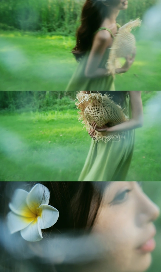 一位穿着绿色连衣裙拿着白色花朵的女人