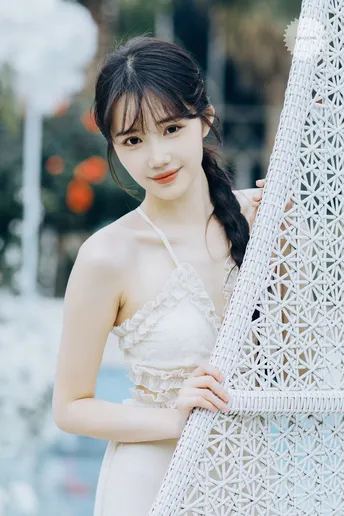 一位穿着白色连衣裙的女子在艺术展览前摆姿势