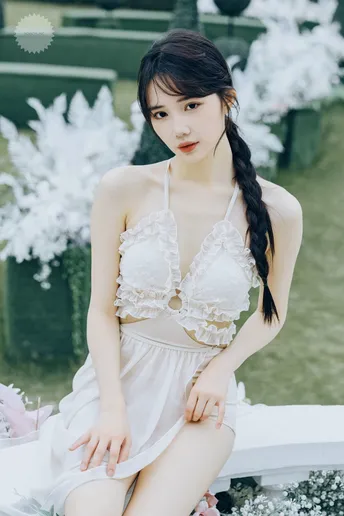 一位长发女子穿着白色裙子在花园里