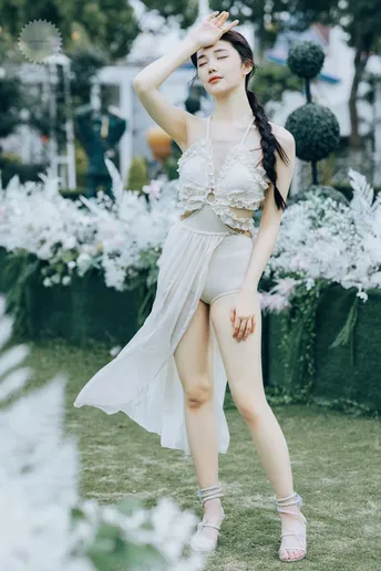 一位穿着白色连衣裙的女士在花园的草地上