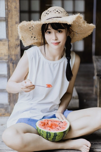 一位戴着帽子吃西瓜的年轻女子坐在地板上