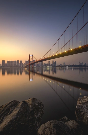 日出或日落时 河上的一座桥 背景是城市