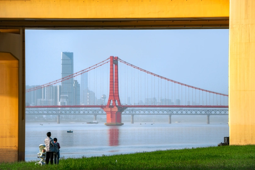 从金门大桥和河对岸的城市角度看 一对夫妇坐在桥边