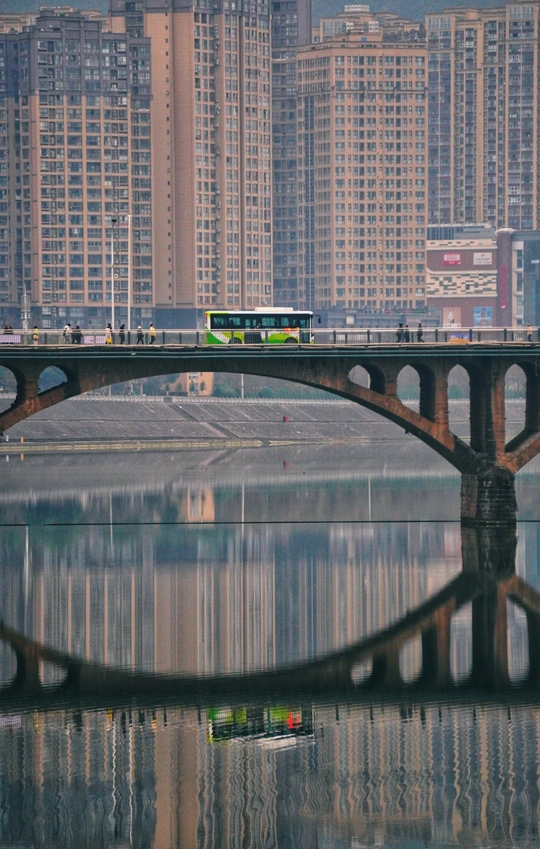 靠近城市的广阔水域 高耸的建筑物 以及行驶在桥上的火车或公共汽车。