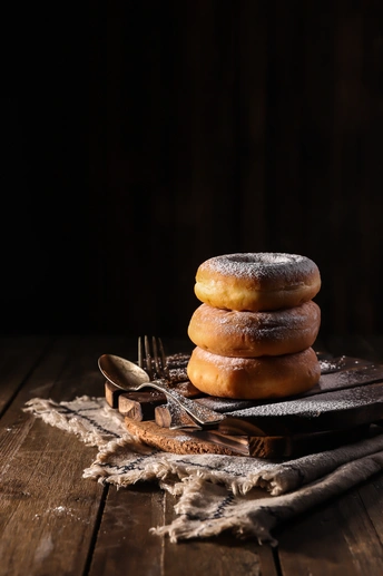 一堆甜甜圈坐在木桌上的一块盘子上