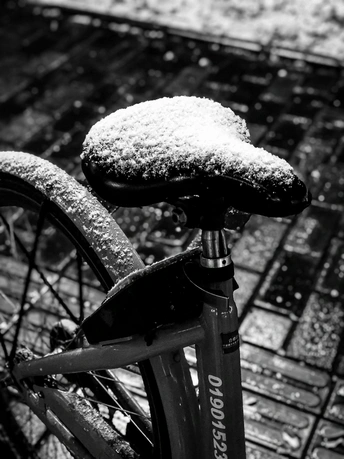 一辆自行车停在人行道上 被雪覆盖。