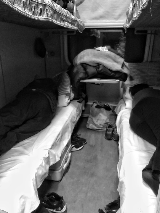 人们在火车上一个小房间里睡在小型单人床。