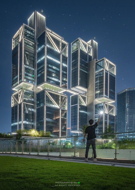 站在高楼前拍照的城市夜景的男人