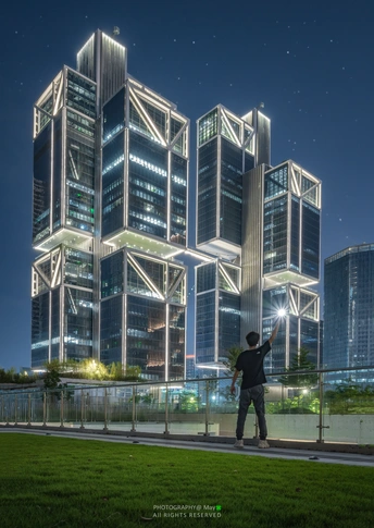 站在高楼前拍照的城市夜景的男人