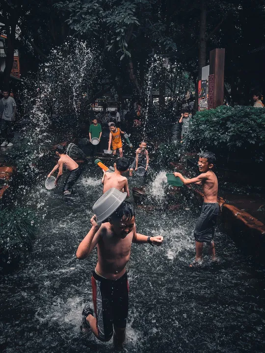 年轻男孩在河里玩水桶
