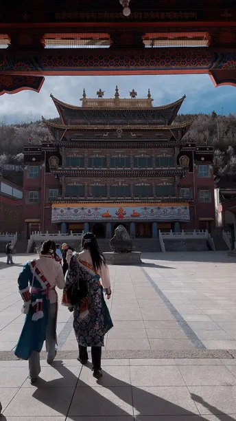 穿着和服的人们穿过一个有大门的建筑物前的庭院