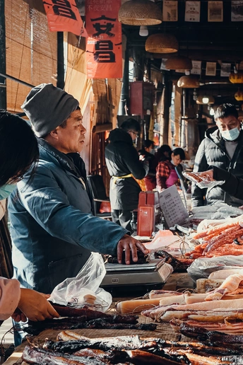 一个男人和一个女人在一个鱼市上看着海鲜。