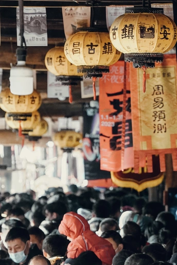 挂着灯笼下的人们都戴着口罩