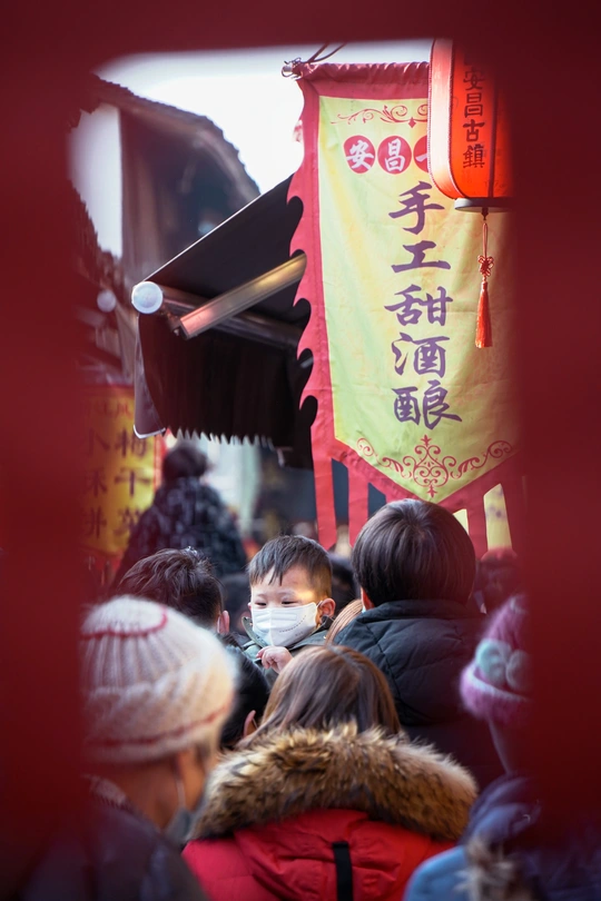 戴口罩的人群站在拥挤的街道上