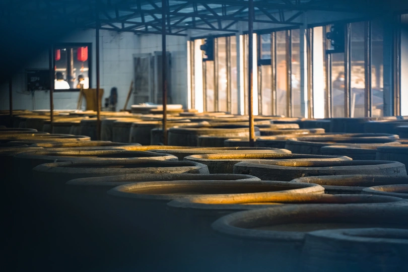 一个大型仓库 里面有排轮胎 轮胎正坐在桌子上的阴影中。