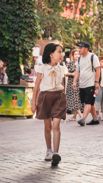 一个小女孩走在一条小街上