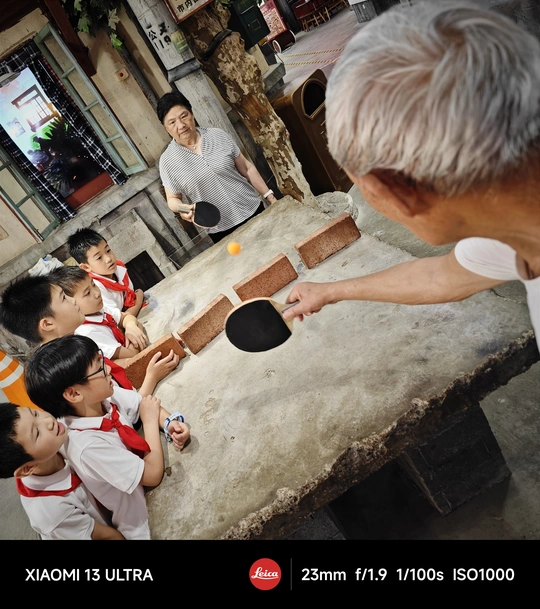 一个与年轻孩子们在桌子上打乒乓球的男子