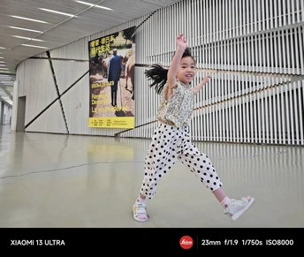 一个小女孩在金属墙前跳起来