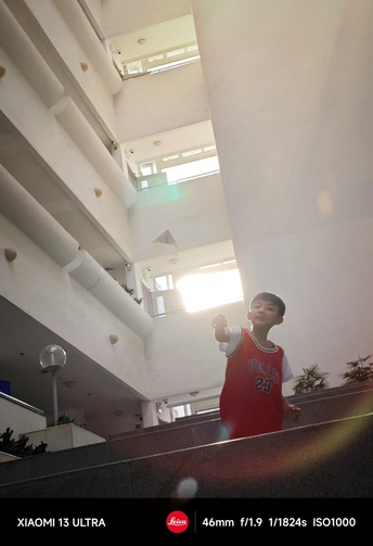 一个站在建筑物内的楼梯上 手里拿着一个球的年轻人。