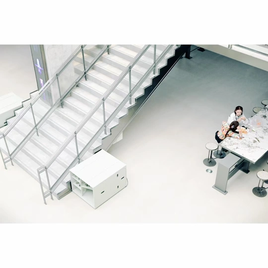 一个男子和一个女子坐在带有楼梯的办公室桌子旁