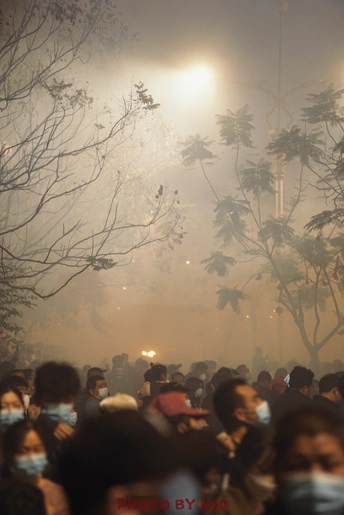 雾气缭绕的夜晚 一群戴口罩的人们站在烟雾弥漫中。