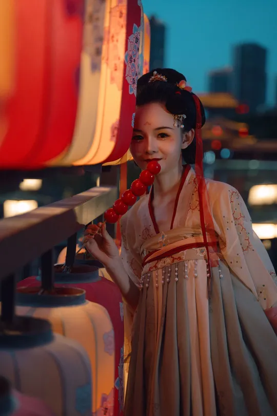 一位身着中国传统服装的年轻女子在红灯笼前摆姿势