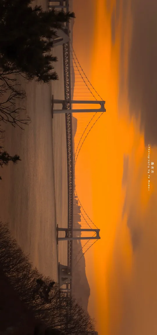 太阳低垂在堤坝上方和电力线之上