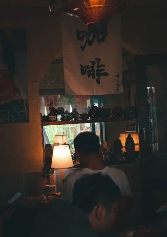 夜晚一个被灯照亮的黑暗房间 有一对夫妇坐在桌子旁。