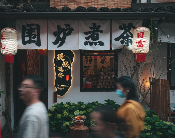 戴口罩的人们走过一家餐厅