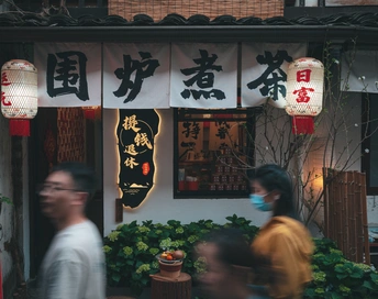 戴口罩的人们走过一家餐厅