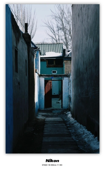 一条狭窄的巷子 一扇蓝色的门 在一座老房子里