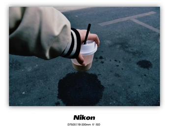 一张手拿着一杯咖啡的图片 上面插着一根吸管。