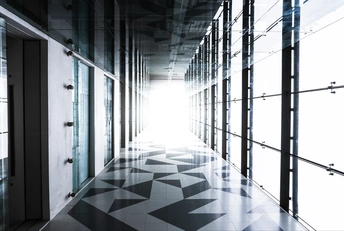 一个现代化的建筑中的长走廊 地面为黑白棋盘式图案。