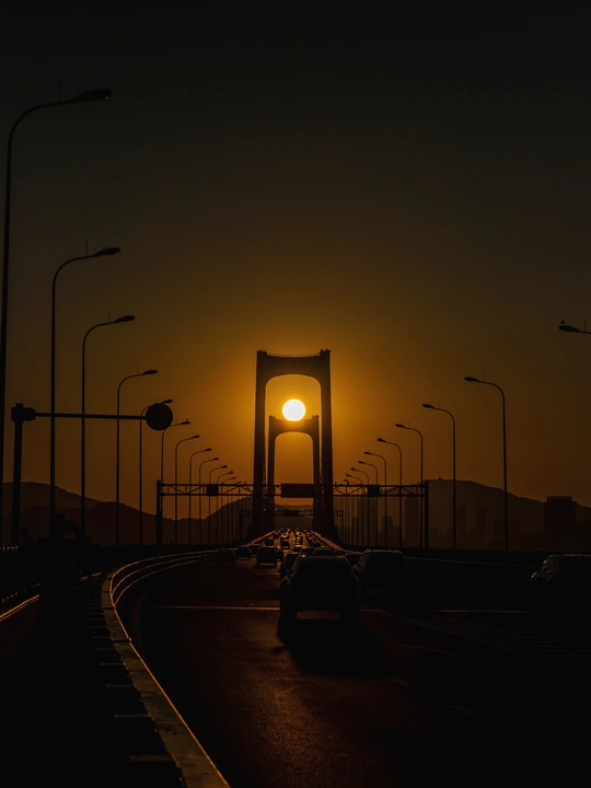 汽车在桥下日落时行驶在道路上