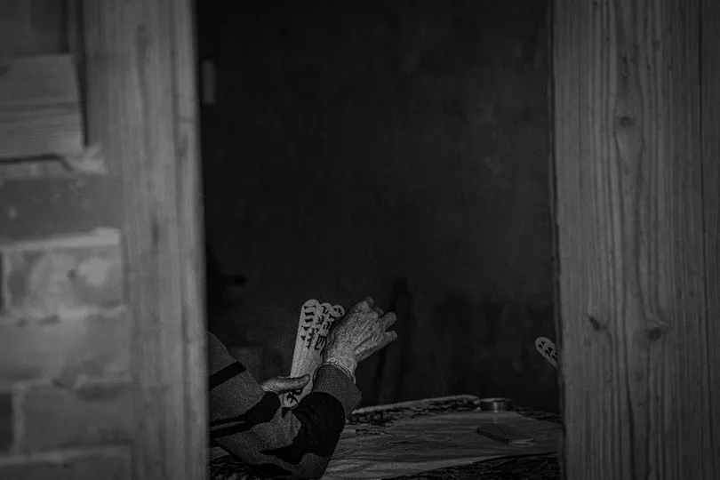 一把带有报纸的椅子坐在老房子的大门里