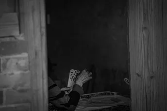 一把带有报纸的椅子坐在老房子的大门里