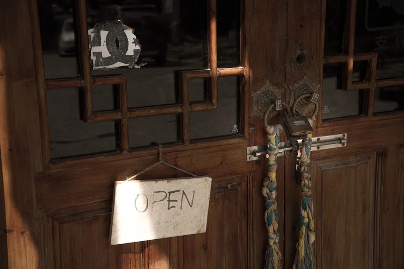 a cross hanging in a room with wooden walls and wi